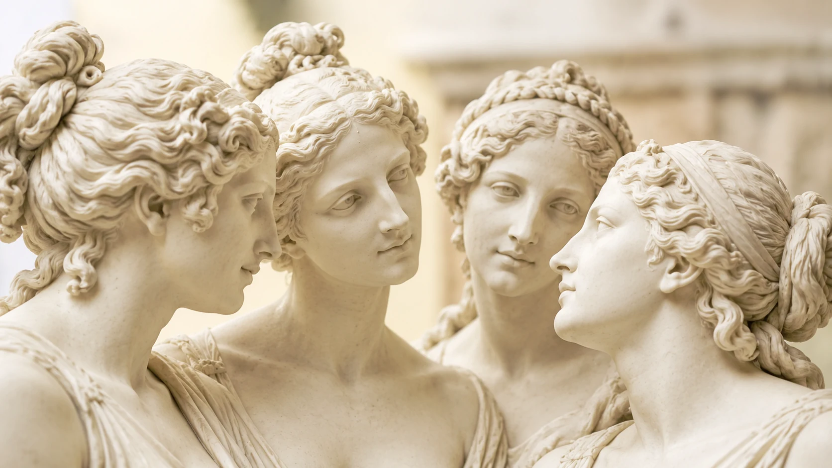 Vier vrouwelijke sculpturen in een aandachtige kring